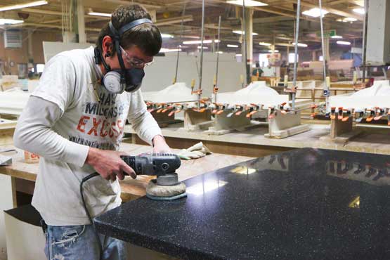 Young man sanding a Meganite Solid Surface Top